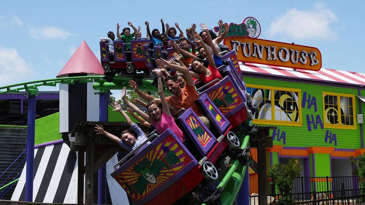 kids on the Joker Funhouse Coaster with Funhouse in the background at Six Flags Over Georgia in Atlanta, Georgia, USA